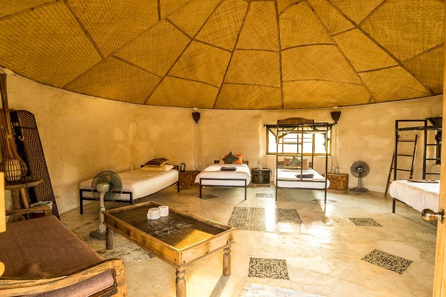 Inside the adobe dorm at Mala Dhara — single beds beneath a woven domed ceiling