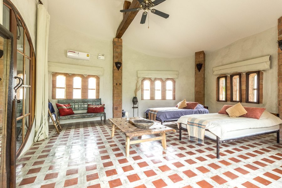 Inside one of the Mala villas at Mala Dhara — twin beds, arched windows and a tiled floor