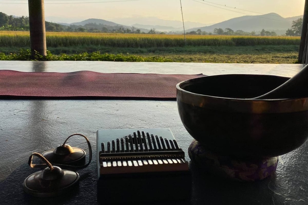 A mat and singing bowl laid out in the open-air Rice Paddy Shala, looking over the paddies to the mountains